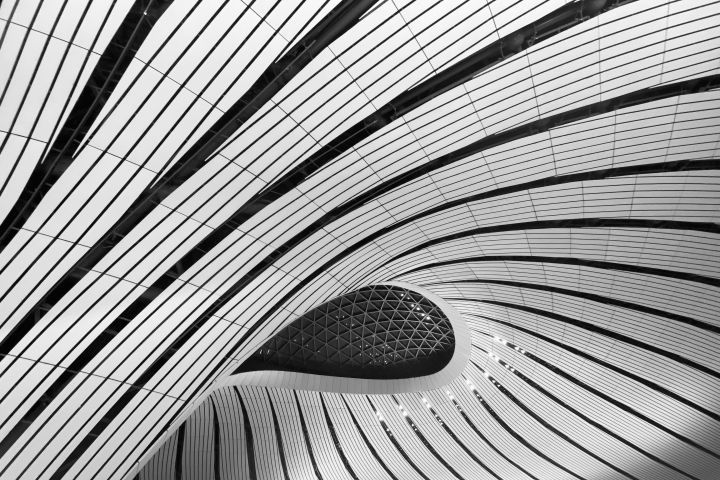 Explore the intricate curved design of Beijing Daxing Airport's modern architecture.